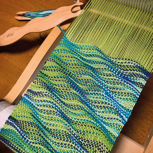 The Good Yarn Using Wavy Shuttles . Ashford Rigid Heddle loom with Blue and Green cotton